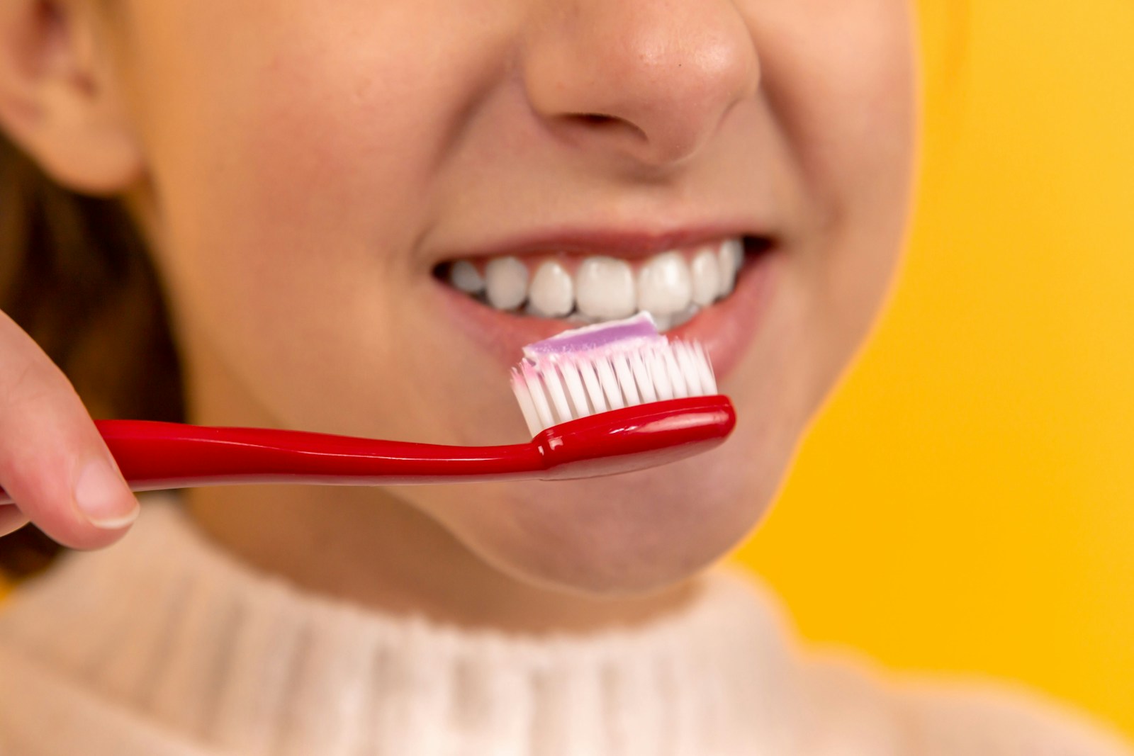 girl with red and white toothbrush in mouth with dental insurance
